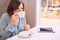 Woman sipping cappaccino in a bright cafe with tablet