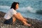 Woman sits ashore of sea