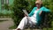 Woman sits on the bench and communicates via tablet PC