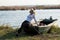 The Woman Sits On A Boat On The Lake Shore