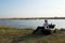 The Woman Sits On A Boat On The Lake Shore