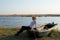 The Woman Sits On A Boat On The Lake Shore