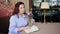 woman sits in a cafe or on the veranda, corrects the bouquet, reading a book