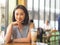 Woman sits in coffee cafe wirh iced coffee on table.