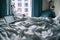 Woman sits with cup of tea in hotel room at the rain morning