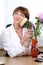 Woman sits at the desk hugging flowers bouquet