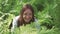 A woman sits in the fern thickets and laughs