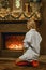A woman sits on the floor near the fireplace photo