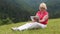 Woman sits on the grass and uses tablet PC