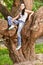 Woman sits on huge tree i