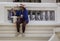 Woman sits on ledge painting a balcony