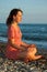 Woman sits and meditation ashore of sea