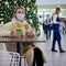 A woman sits in a new year cafe with a medical mask on her face. Holidays during the flu virus pandemic, lifestyle