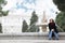 Woman sits next to fountain in gardens of Sabatini