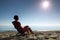 Woman sits on plastic chair sideways on beach