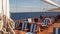 A woman sits at a table on the open deck of a sailing yacht