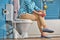 Woman sits on toilet bowl in the bathroom, bottom view