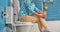 Woman sits on toilet bowl in the bathroom, bottom view