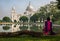 A woman sits at the Victoria Memorial architectural building garden beside the south lake