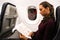 A woman sits at the window of an airplane at night