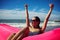 A woman sitting on the air rubber raft on the beach and holding