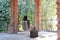 A woman sitting alone on a swing amidst of pillars made up of bricks at sunrise