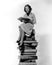 Woman sitting atop pile of books