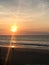 Woman Sitting on Beach Meditating at Sunset