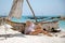 Woman sitting on the beach near the boat.