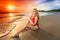 Woman sitting on the beach on sunset