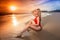 Woman sitting on the beach on sunset