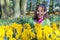 Woman sitting behind daffodils in park