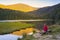 A woman sitting on a bench at beautiful Small Arber lake in the Bavarian Forest at sunset. View to mount GroÃŸer Arber