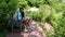 Woman sitting on bench on on brick patio surrounded by by plants and bushes