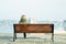 Woman sitting on bench on embankment with amazing view on sea