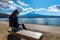 Woman sitting on a bench at kawaguchiko lake, Japan. View of fuji mountains