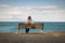 Woman sitting on a bench looking at the sea on the Costa Brava