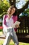 Woman sitting on bench and using digital tablet in garden