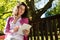 Woman sitting on bench and using digital tablet in garden