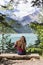 Woman sitting on a bench watches the lake