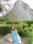 A woman is sitting on a big stone in front of Khau Chee Chan mountain in Thailand