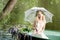 Woman sitting in boat under lace umbrella. Summer