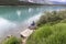 Woman sitting on a boulder next to a lake.