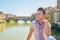 Woman sitting on bridge overlooking ponte vecchio