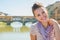 Woman sitting on bridge overlooking ponte vecchio