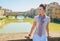 Woman sitting on bridge overlooking ponte vecchio