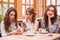 Woman sitting in cafe while her girlfriends using smartphones