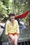 Woman Sitting On Car Bonnet In Forest