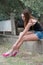 Woman sitting on cement short wall