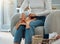 Woman sitting on a chair folding laundry. Woman cleaning her clothing, doing housework. Woman doing chores at home